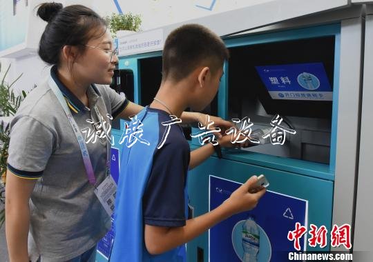 圖為小朋友感受用智能垃圾箱掃碼扔垃圾。　周毅　攝