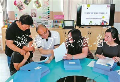 無錫市廣新小學(xué)校長過秦勇（右三）、副校長朱甄珍（右一）與梁溪區(qū)特教指導(dǎo)中心資源教師陳向華（右二），和學(xué)生小芮及家長一起商量個別化教育方案。