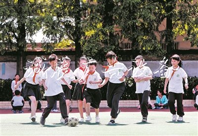 在無錫市廣新小學(xué)操場上，隨班就讀學(xué)生小瑩、小俊和同學(xué)們一起踢足球。陽光下，孩子們臉上綻放出燦爛的笑容。
