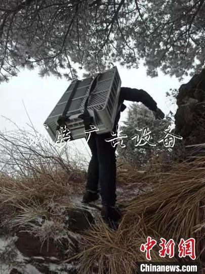 技術人員冒著風雪攀爬上陡坡 王政 攝 技術人員冒著風雪攀爬上陡坡 王政 攝